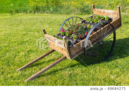 Vintage wooden cart with potted flowers Vintage wooden cart with potted flowers 89684275