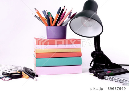 table lamp and colorful school supplies on white background .photo with copy space table lamp and colorful school supplies on white background .photo with copy space 89687649
