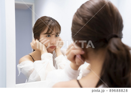 鏡で自分を見つめる女性のポートレート 89688828