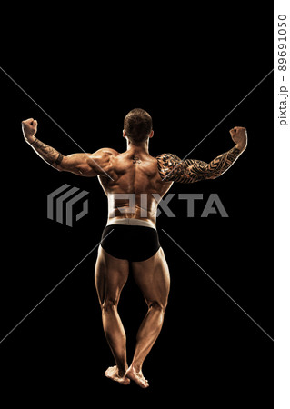 bodybuilder posing. Beautiful sporty guy male power. Fitness muscular body. Isolated on black background 89691050