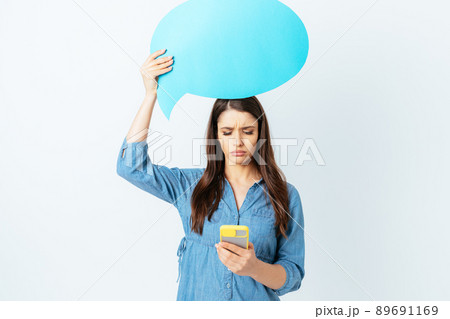 Portrait sad brunette girl holding empty communication bubble 89691169