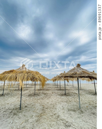 Straw beach umbrellas on a blue sky and sea background.Copy space Straw beach umbrellas on a blue sky and sea background.Copy space 89691337