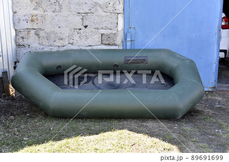 Green rubber boat for fishing in the yard 89691699
