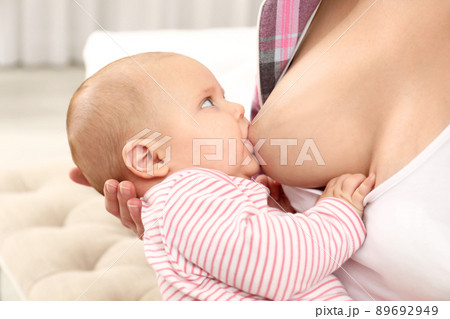 Young woman breastfeeding her little baby at home, closeup Young woman breastfeeding her little baby at home, closeup 89692949