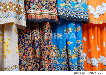 Fenghuang, Hunan Province, China: Colorful fabric of dresses for sale in a fashion shop in Fenghuang. Shallow depth of field on blue dress. Fenghuang, Hunan Province, China: Colorful fabric of dresses for sale in a fashion shop in Fenghuang. Shallow depth of field on blue dress. 89693777