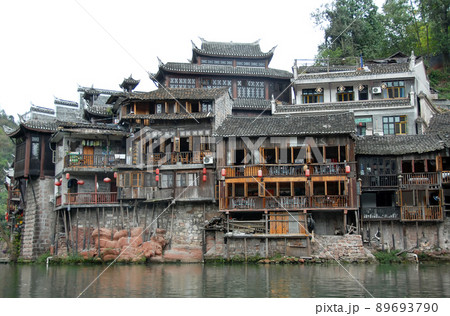 Fenghuang, Hunan Province, China: Old wooden riverside houses in Fenghuang ancient town. The town is built on the Tuojiang River and is home to Miao and Tujia minority peoples. Fenghuang, Hunan Province, China: Old wooden riverside houses in Fenghuang ancient town. The town is built on the Tuojiang River and is home to Miao and Tujia minority peoples. 89693790