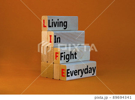 LIFE living in fight everyday symbol. Concept words LIFE living in fight everyday on wooden blocks on a beautiful orange background. Business LIFE living in fight everyday concept. Copy space. 89694341