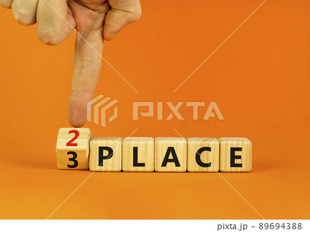 From 3 to 2 place symbol. Businessman turns wooden cubes and changes concept words 3 place to 2 place. Beautiful orange table orange background. Business and from 3 to 2 place concept. Copy space. 89694388