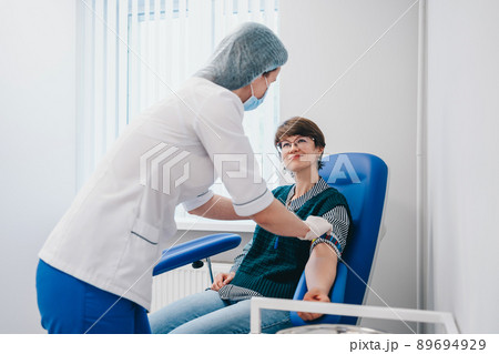 The patient takes a blood test at the clinic. The patient takes a blood test at the clinic. 89694929