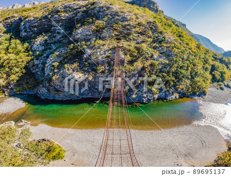 Sights of Montenegro. Landmark Old rusty bridge. Attraction Long extreme suspension iron bridge across the river Moraca. Montenegro 89695137