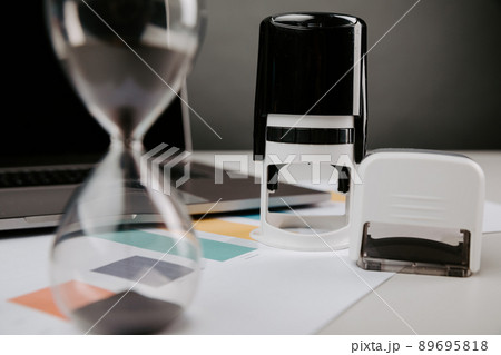 Office desk table with laptop, hourglass and rubber stamp. Concept of contract, consent, clerk working in the office 89695818