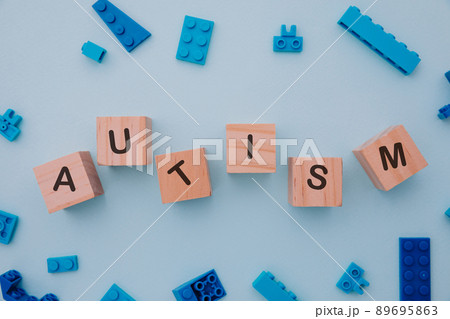 Puzzles and wooden blocks with AUTISM word. Close-up. World autism awareness day concept Puzzles and wooden blocks with AUTISM word. Close-up. World autism awareness day concept 89695863