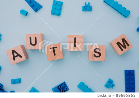 Blue puzzle and wooden blocks with AUTISM word. Close-up. World autism awareness day concept Blue puzzle and wooden blocks with AUTISM word. Close-up. World autism awareness day concept 89695865