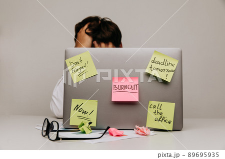 Worker have sticker pads on his laptop with tasks. Burnout theme 89695935