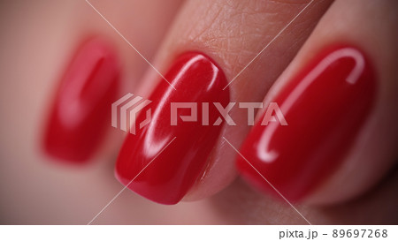 Red bright glossy nails on female nails closeup 89697268
