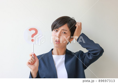 はてなのプレートを持ち頭に手を当てる女性2 はてなのプレートを持ち頭に手を当てる女性2 89697313