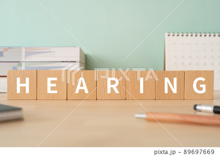 ヒアリングのイメージ｜「HEARING」と書かれた積み木が置かれたデスク 89697669