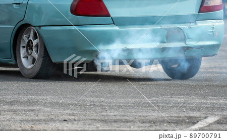 Old car emits pollutant out of the exhaust on street. Air pollution concep. Old car emits pollutant out of the exhaust on street. Air pollution concep. 89700791