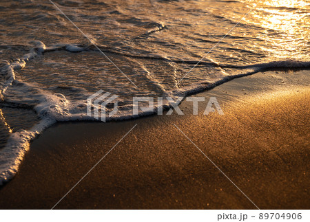 オレンジに輝く波際と砂浜 オレンジに輝く波際と砂浜 89704906