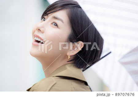 傘をさして歩く女性 傘をさして歩く女性 89707676