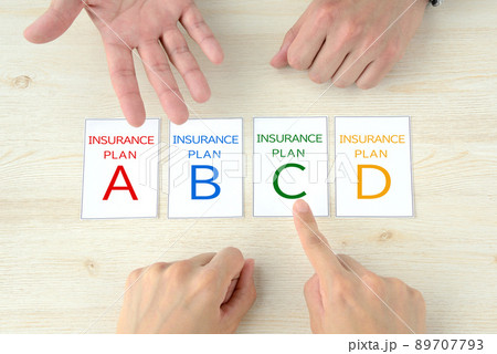 保険のプランを話し合う夫婦・外交員の手元 89707793