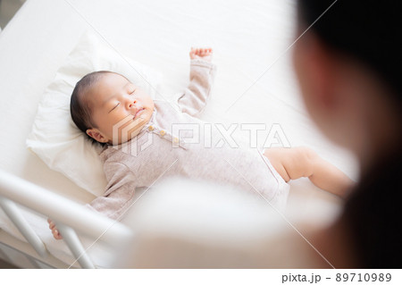 女性越しの眠る赤ちゃん 女性越しの眠る赤ちゃん 89710989