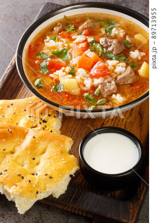 Uzbek Mastava rice soup with meat and vegetables closeup in the bowl. Vertical Uzbek Mastava rice soup with meat and vegetables closeup in the bowl. Vertical 89713955