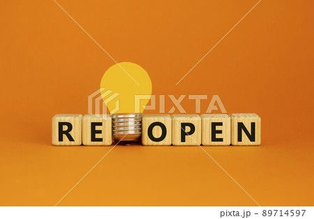 Reopen symbol. Wooden cubes with word 'reopen'. Yellow light bulb. Beautiful orange background. Business and reopen concept. Copy space. Reopen symbol. Wooden cubes with word 'reopen'. Yellow light bulb. Beautiful orange background. Business and reopen concept. Copy space. 89714597