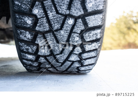 Winter studded tire tread standing in the snowdrift close up after a hard snow storm in winter 89715225