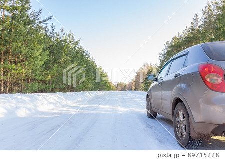 Car on winter snow road in coniferous forest 89715228