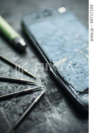 Smartphone with a broken screen and repair tools. Close-up. 89717109