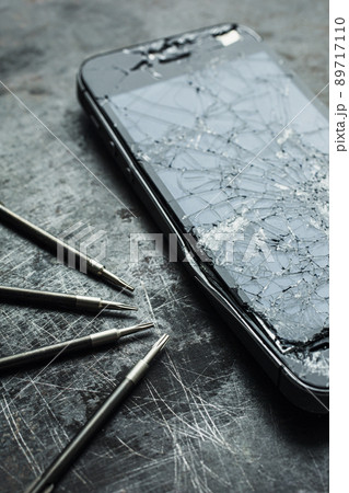 Smartphone with a broken screen and repair tools. Close-up. 89717110