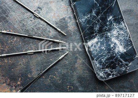 Smartphone with a broken screen and repair tools. Close-up. 89717127