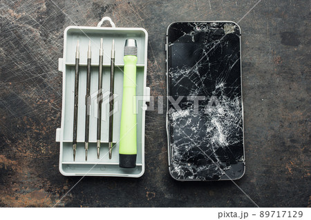 Smartphone with a broken screen and repair tools. Close-up. 89717129