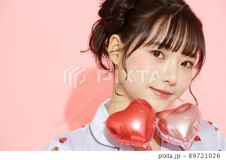 パジャマを着た若い女性のピンク背景のポートレート 89721026