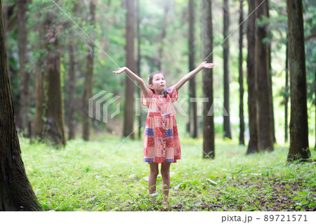 森の中で両手を広げる少女 89721571