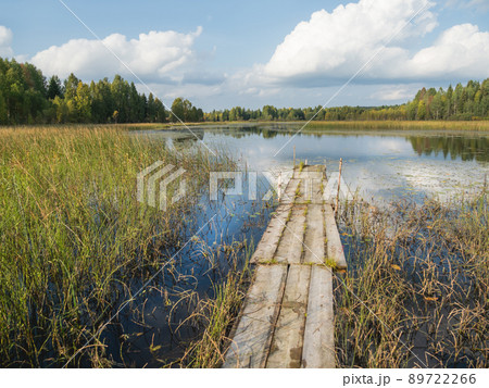 Wooden mooring for boats on Lake Kenozero. Beautiful landscape of clear water and autumn nature. Russia. 89722266