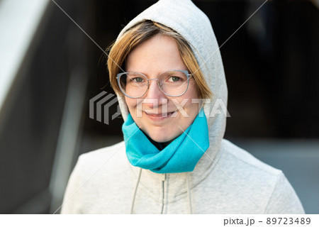 Portrait of a 35 year old woman wearing a hoody, looking confident 89723489
