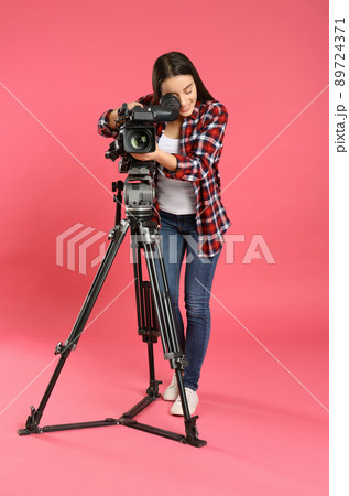 Operator with professional video camera on pink background 89724371