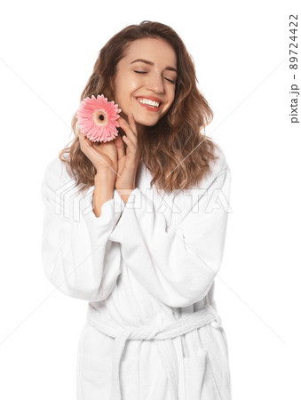 Beautiful young woman with flower wearing bathrobe on white background Beautiful young woman with flower wearing bathrobe on white background 89724422