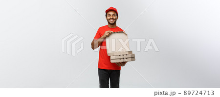 Delivery Concept - Portrait of Handsome African American Pizza delivery man. Isolated on Grey studio Background. Copy Space. 89724713