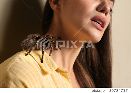 Young woman with tarantula on beige background, closeup. Arachnophobia (fear of spiders) 89724757