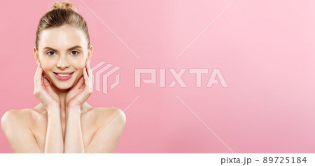 Beauty Concept - Beautiful Caucasian woman with clean skin, natural make-up isolated on bright pink background with copy space. Beauty Concept - Beautiful Caucasian woman with clean skin, natural make-up isolated on bright pink background with copy space. 89725184