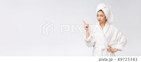 Young beautiful woman wearing shower towel after bath over isolated white background pointing with finger. 89725383