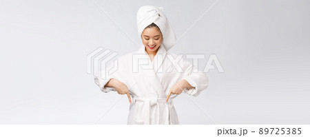 Beauty portrait of young woman showing and pointing finger to empty copy space, asian beauty in bathrobe. 89725385