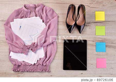 Top view flat lay pink blouse with work papers and shoes. 89726106