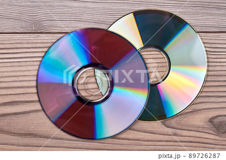 Pair of compact discs on a wooden background. Pair of compact discs on a wooden background. 89726287