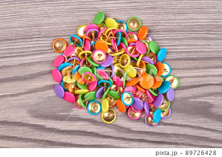 Top view pile of push pins on white wooden desk. Top view pile of push pins on white wooden desk. 89726428