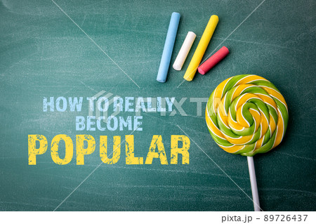 How To Really Become Popular. Colored pieces of chalk and candy on a green board 89726437