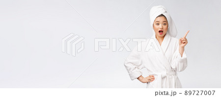 Beauty portrait of young woman showing and pointing finger to empty copy space, asian beauty in bathrobe. 89727007